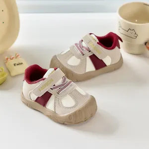 Détail de chaussures de marche pour bébés crème et bordeaux avec embout protecteur