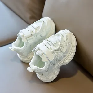 Detail view of white toddler sneakers with breathable mesh, velcro strap, and thick rubber sole