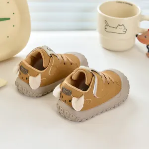 Détail de chaussures de marche bébé avec motif chien et oreilles en peluche