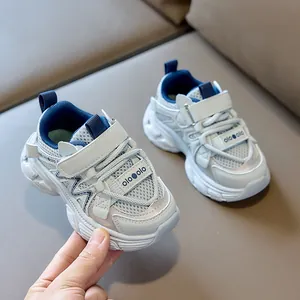 Detail view of breathable mesh texture and velcro strap on beige kids sneakers