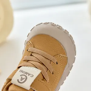 Vue macro de chaussures de marche kaki pour bébé avec texture cuir et bout protecteur en gomme