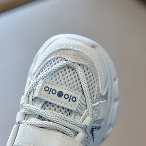 Detailed macro view of breathable mesh and leather stitching on kids' running sneakers