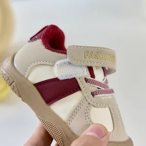 Gros plan de chaussures de marche pour bébé en cuir bordeaux avec attache velcro fashion