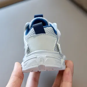 Detail of grey breathable mesh kids sneakers showing heel pull tab and anti-slip sole