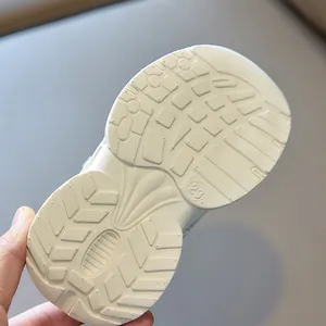 Detail view of anti-slip beige rubber sole with size 23 mark for kids sneakers