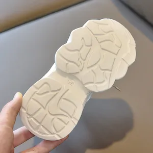 Close-up of anti-slip rubber sole with multi-directional grip on white kids sneakers