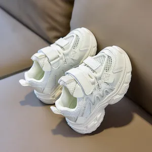 Detail view of white kids' mesh sneakers with double hook and loop straps on leather