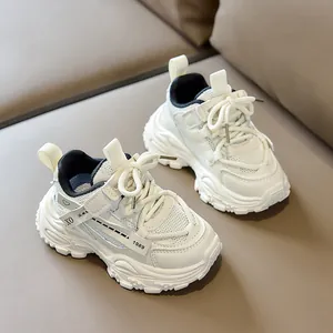 Detail of white kids sneakers with mesh paneling and non-slip thick saw-tooth sole