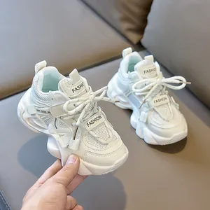 Detailed close-up of breathable mesh upper and durable sole on kids' beige sneakers