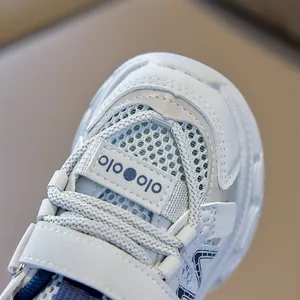 Detail view of breathable double-mesh fabric and velcro closure on white kids' sports shoes