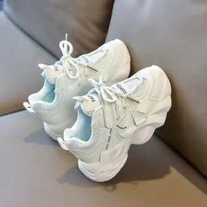 Detail of white children's chunky sneaker with mesh upper and wave-patterned sole