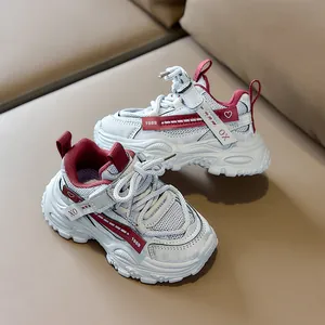 Detail of gray kids mesh sneakers with red accents, velcro straps and thick soles