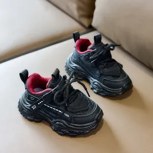 Detail of kids breathable mesh sports shoes with red lining on a leather sofa