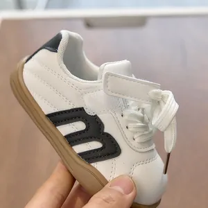 Detalle de zapatillas de cuero para niños con velcro y suelas de goma marrones