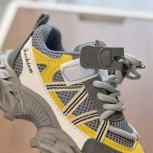 Detail of children's sports shoes showing breathable grey mesh and anti-slip rubber sole