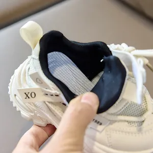 Detail of breathable cream mesh sneakers with thick padded ankle support and XO tags