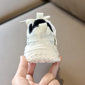 Close-up of the breathable mesh upper and anti-slip rubber sole on kids' sneakers