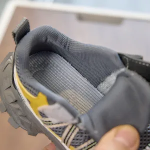 Detailed macro view of children's sports shoes showing thick mesh lining and yellow star detail