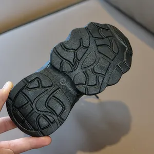 Macro shot of durable black rubber sole with wave texture and size 28 mark for kids sneakers