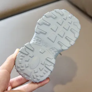 Detail of blue kids sports shoe sole with anti-slip tread pattern and size 23 mark