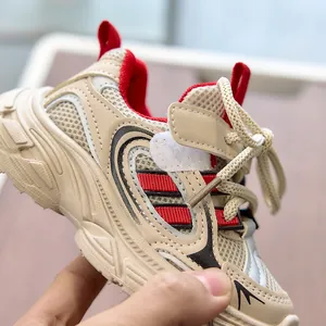 Detail of breathable mesh and faux leather stitching on beige kids sports sneakers