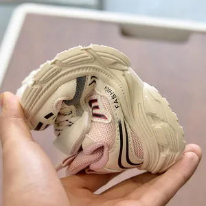Flexible soft sole of cream kids sneakers being bent to show high elasticity and comfort
