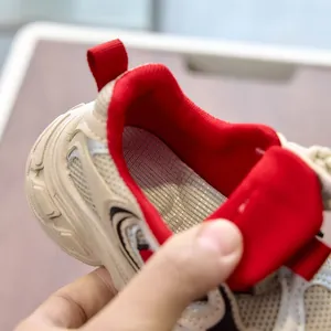 Detail of breathable mesh upper and vibrant red lining on kids fashion sports sneaker
