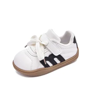 Zapatillas blancas minimalistas para niños con rayas negras y suela de goma