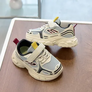 Close-up of kids mesh sneakers with velcro strap, beige and grey breathable sports shoes