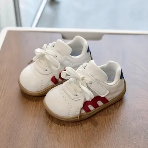 Zapatillas blancas de piel para niños con M roja, velcro y detalle azul talón