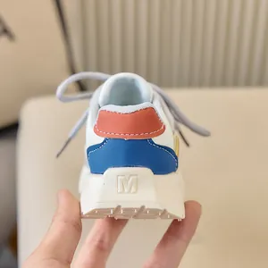 Vue détaillée du talon de basket enfant avec empiècements en cuir bleu et orange