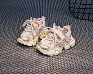 Detail of children's mesh sneakers with beige upper and metallic gold trimming detail