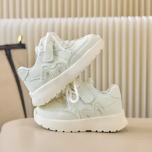 Détail de basket enfant montrant le cuir menthe, le logo M et la bride velcro