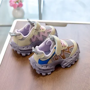 Detail view of children sports shoes with mesh upper and velcro strap on wood surface