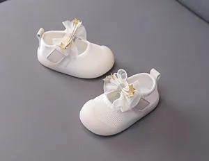 Detail of baby girl Mary Jane shoe with mesh bow, golden stars, and ivory fabric texture