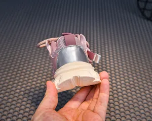 Detail of pink mesh children sneakers with thick wavy sole and silver heel accent