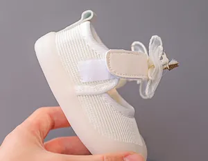 Detailed close-up of white mesh toddler walking shoes with star-embellished tulle bows