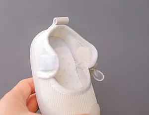 Detail view of white baby walking shoe with breathable mesh and velcro closure