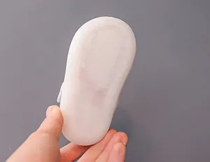 Detailed macro view of the translucent non-slip soft rubber sole on a baby walking shoe