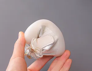 Flexible soft sole of baby walking shoes shown being bent to demonstrate comfort