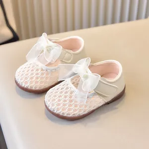 Détail de chaussures bébé en maille crème avec grand nœud en tulle et texture respirante