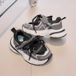 Detailed close-up of kids' breathable mesh sneakers with hook-and-loop straps in grey and black