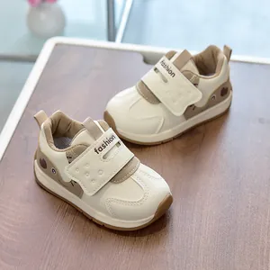 Detail view of cream leather toddler sneakers featuring brown heart cartoons and fashion velcro