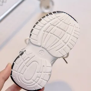 Detail view of anti-slip white rubber sole with size 23 engraving on kids athletic shoes