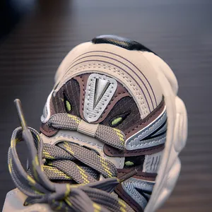 Close-up of children's mesh running shoe with beige panels and neon green stitching