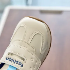 Close-up of cream leather toddler sneakers featuring velcro strap and rubber sole