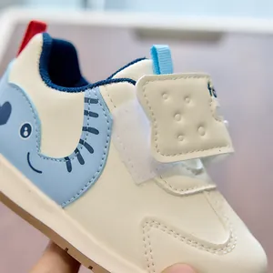 Close-up of baby sneakers featuring a light blue cartoon elephant and velcro strap detail