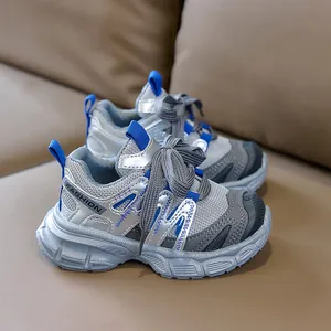 Détail des coutures en maille grise et cuir synthétique argenté sur chaussures de sport