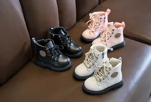 Detail of children's warm leather boots in black, pink, and beige with soft fur lining