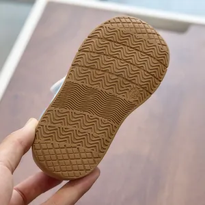 Macro shot of non-slip brown rubber sole with wavy grip texture and size 23 engraving